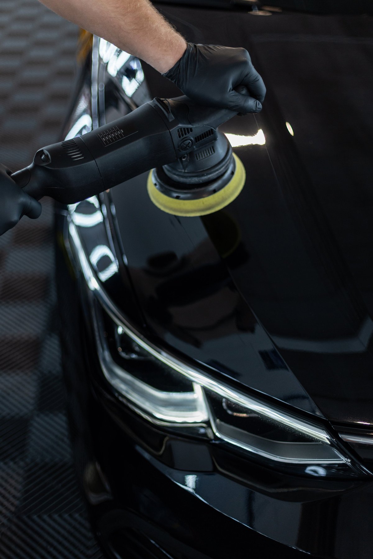 Professional detailer polishing a clean vehicle exterior