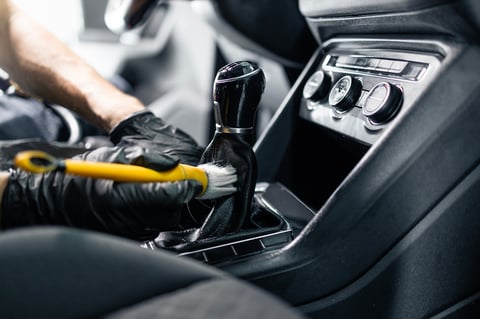 Professional detailer cleaning the interior of a vehicle