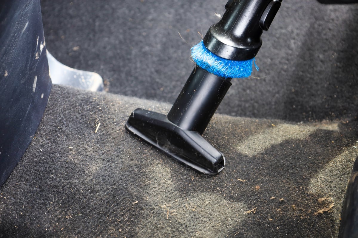 A special vacuum cleaner nozzle thoroughly cleans the pile surface of the car carpet from dust and small debris during interior cleaning.