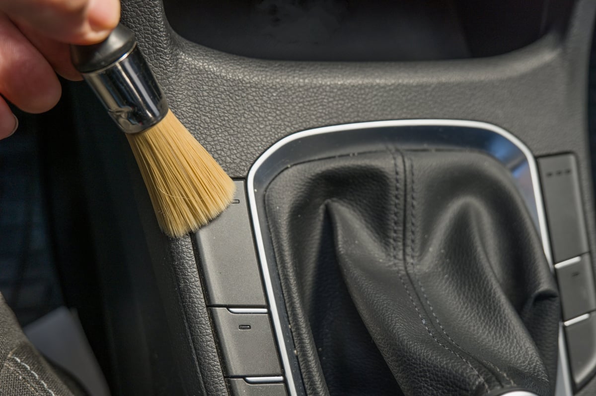 Detailed Car interior cleaning . Hand holding and using soft brush